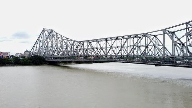 Transport on bridge with vehicles moving across a modern steel structure of Howrah bridge.