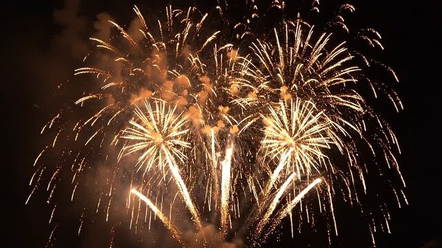 Bright golden fireworks exploding in the night sky celebration