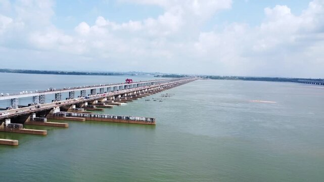 Large Scale Hydroelectric Dam Infrastructure and Water Control System. Multi-Lane Roadway Over Large River Dam and Reservoir Bridge. Massive Water Reservoir and Spillway Gates for Regional Irrigation.