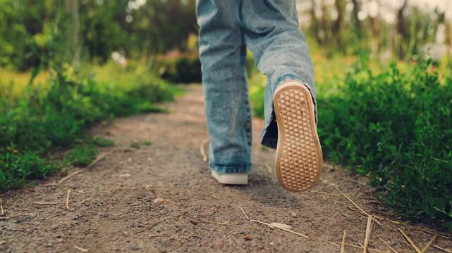 child foot sole in focus during a summer park walk, foot sole firm, foot sole dusty, foot sole shows, walking lightly, walking steadily, child on a park walk, walking barefoot feel in shoes, on a