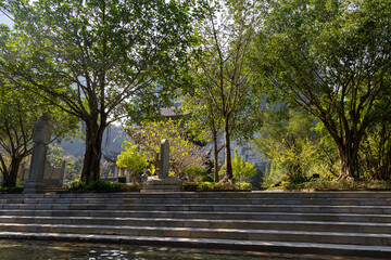 A woman stands on steps in Trang An, Ninh Binh, Vietnam, enjoying the scenery. The location is a popular tourist destination in Vietnam.