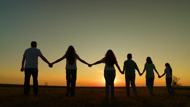sharing hope: sunset unity scene, sunlit family unity holding hands together, sunset horizon of hope: people connected as one, joy in unity: sunset silhouettes across the meadow, raising hands to the