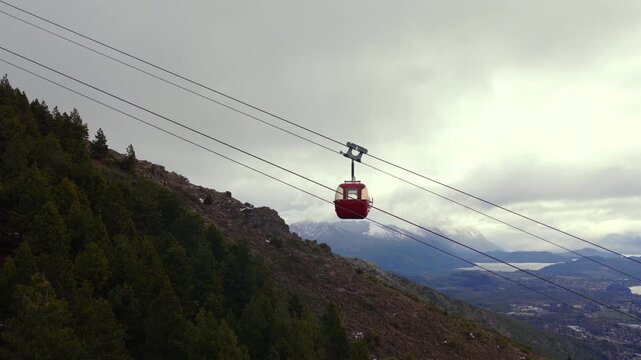 Cable car gondola traveling above forested slope at Cerro Otto San Carlos de Bariloche Argentina