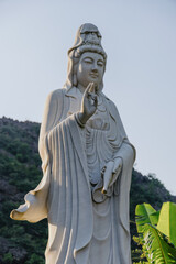 Fototapeta premium A serene Quan Am statue stands in Hoa Lu Ancient Capital, Ninh Binh, Vietnam. The statue is a symbol of compassion and mercy, inviting contemplation and peace.