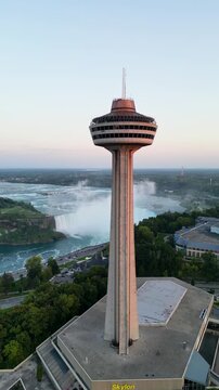 Cinematic aerial drone footage orbiting around the Skylon Tower and revealing the Rainbow Bridge spanning the Niagara River between Canada and the United States near Niagara Falls.