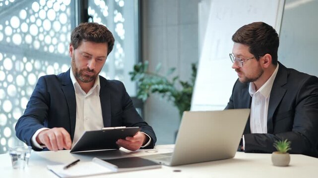 Professionals finalize deal in modern office. Document signing and confident handshake signify successful partnership, expressing satisfaction and trust.