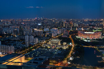 Obraz premium Beijing skyline at dusk with city lights and mountains in the distance
