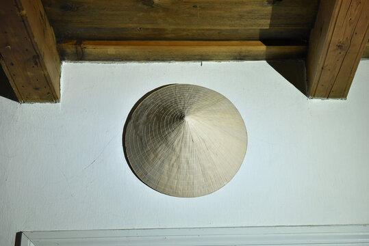 Traditional vietnamese conical leaf hat hanging on a white wall
