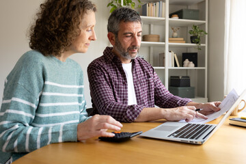 Couple planning family budget discussing finances using laptop © Daniel