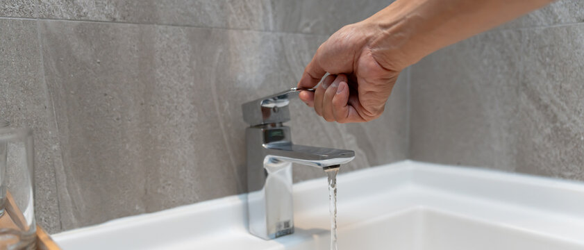 Save water. Man keeps turning off the running water in the bathroom to protect environment. Greening planet, reduce global warming, Save world, life, future, risk energy, crisis , water day.