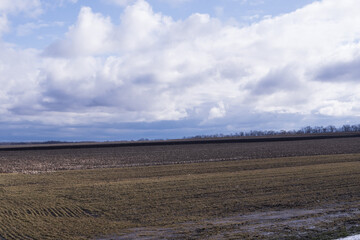 Agricultural farmland landscape with fields and dramatic cloudy sky rural countryside agriculture background