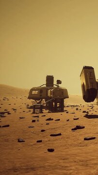 A view of Mars showing two habitat structures on the surface. Rocks are scattered around, and the yellow sky indicates daytime on the red planet.