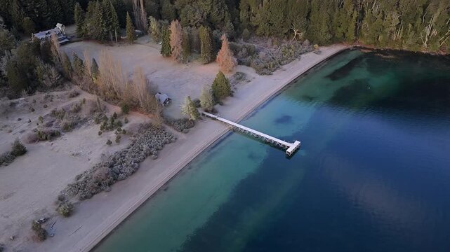 Lago Espejo sandy shoreline and wooden pier in Nahuel Huapi National Park near Villa La Angostura Neuquen Patagonia Argentina, turquoise lake color from glacial flour and volcanic sediment, orbiting