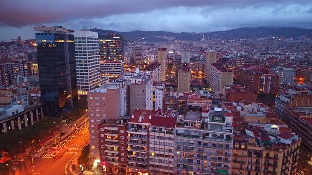Amazing drone fly at The New Left of the Eixample aka La Nova Esquerra de l'Eixample district with late evening cityscape and illuminated urban center, Barcelona, Spain