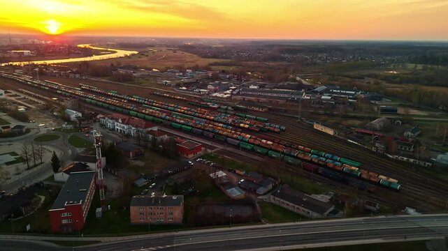 Aerial view over a train marshalling yard during a golden sunrise.