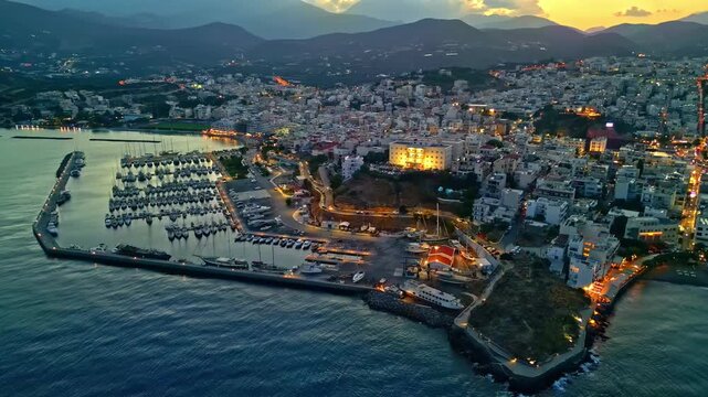 Aerial night view of the coastal town of Agios Nikolaos on the Greek island of Crete.