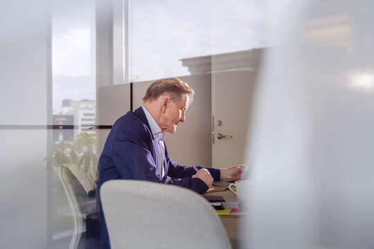 Side view of senior businessman examining documents at office
