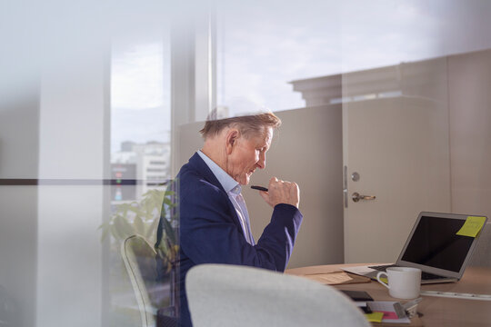 Side view of thoughtful businessman working at office