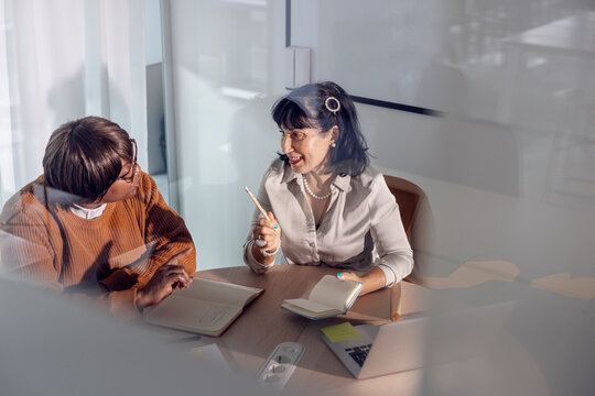 High angle view of businesswoman planning strategy with female colleague at office