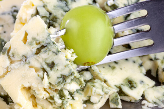 Bite of blue cheese and a grape on fork