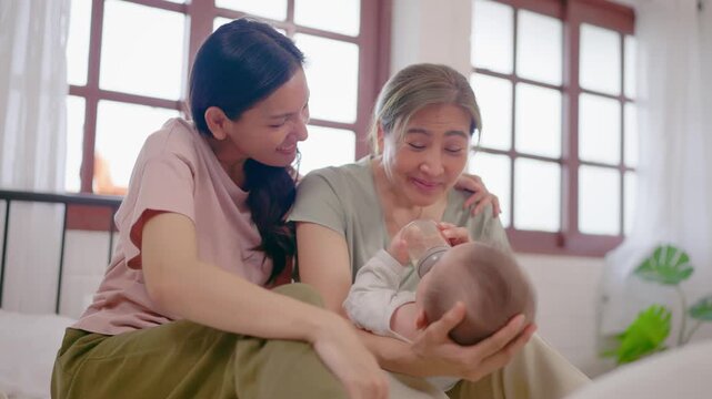 Asian lesbian couple caring for and raising their baby boy at home. 