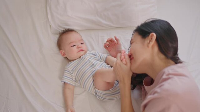 Asian young mother caring for and raising her baby boy at home.