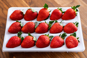 白いトレイに並んだ鮮やかでみずみずしい旬のいちご © Anoconone