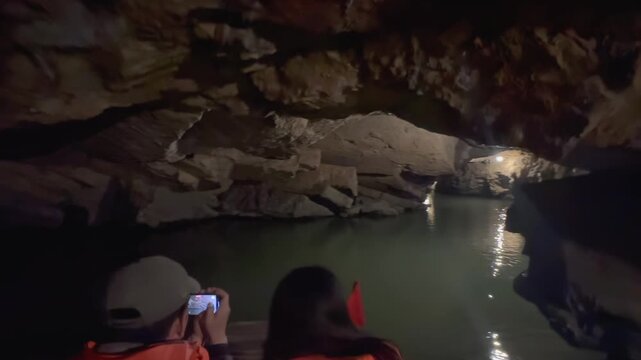 TRANG AN, VIETNAM &ndash; 24 November 2025: Tourists explore the natural beauty of the cave, taking photos of the rock formations and water. ,