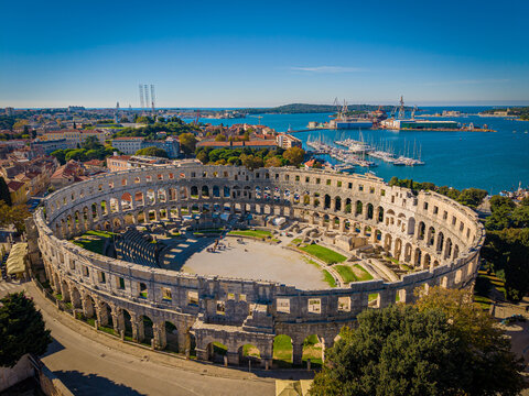 Aerial view of the magnificent Roman amphitheater stands proudly against the azure Adriatic Sea, a testament to ancient grandeur, Pula, Istria County, Croatia.
