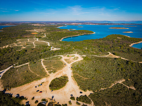 Aerial view of the vibrant contrast between the turquoise Adriatic Sea and the lush green forests of Istria, creating a stunning coastal mosaic, Kamenjak, Istria County, Croatia.