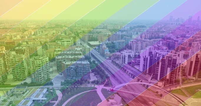 Capturing aerial cityscape spanning urban district, showing highway overpass, park, rainbow overlay