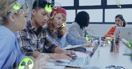 Collaborating five colleagues wearing casual clothes leaning over laptops at studio, with AR icons