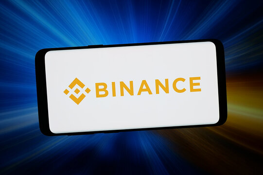 Stuttgart, Germany - 03-06-2026: In this photo illustration, the logo of cryptocurrency exchange Binance Holdings Ltd. is displayed on a smartphone in front of abstract background on computer screen.