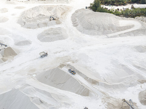 Aerial view of stark white mounds of limestone dominate the landscape, carved by heavy machinery under the bright Florida sun, Miami, Florida, United States.