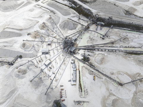 Aerial view of a sprawling limestone quarry with radial conveyor belts creating a stark geometric pattern against the pale earth, Miami, Florida, United States.