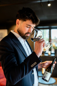 Skilled male sommelier savors and analyzes wine aroma delicately in luxurious ambiance