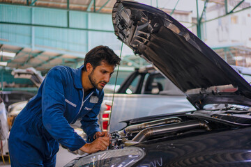 The mechanic is fixing a car at a car repair shop.