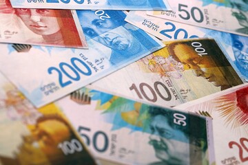 Obraz premium Israel shekel money bills pile on table. Israel banknotes of ILS currency close up.