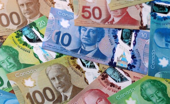 Canadian dollar money bills pile on table. Canada banknotes of CAD currency close up.