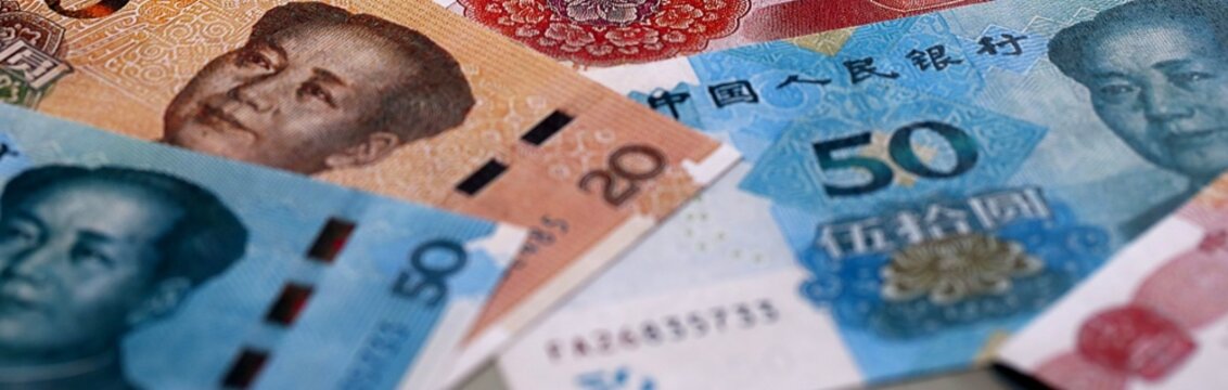 Chinese yuan money bills pile on table. China banknotes of CNY currency close up.