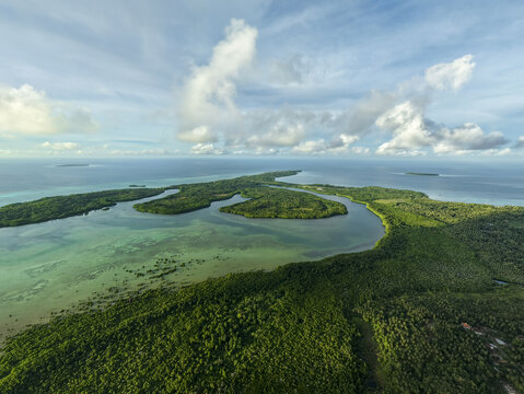 Aerial view of a lush green island embraced by the turquoise sea, a tapestry of nature's finest hues, Karimunjawa, Central Java, Indonesia.