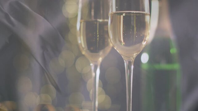 Sheer veil drifting, two flutes clearing and showing bubbles, camera pulling focus showcasing wine