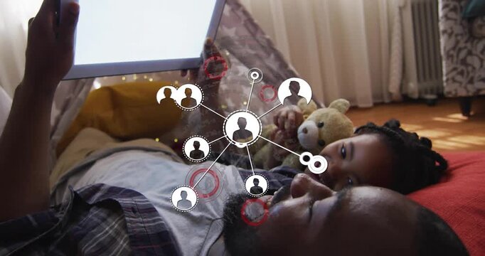 Vertical video: Father holding tablet sparking network nodes over tent, demonstrating tech links