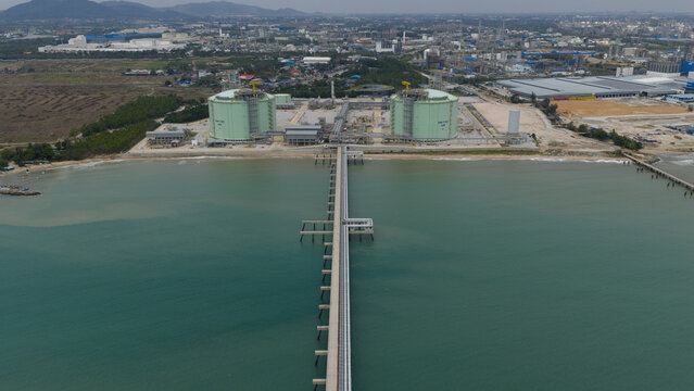 Aerial view of the LNG terminal tanks standing guard over the tranquil sea, a blend of industrial might and coastal serenity, Map Ta Phut, Rayong, Thailand.