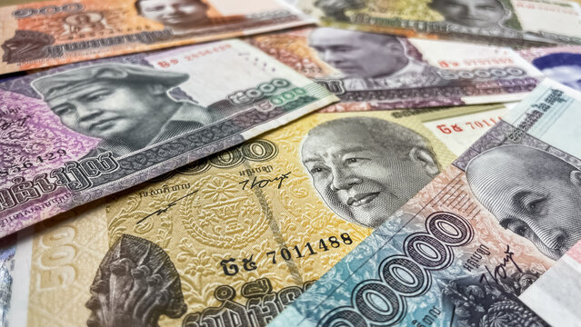 A close-up of various Cambodian riel banknotes laid out on a surface. Concept of finance, economics, and cash.