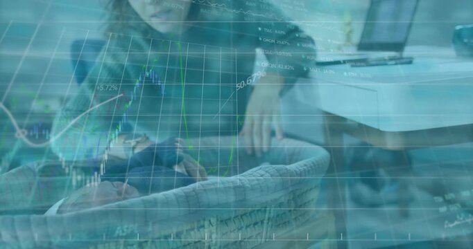 Mother reaching laptop and adjusting baby in bassinet, causing finance graphs over scene for work