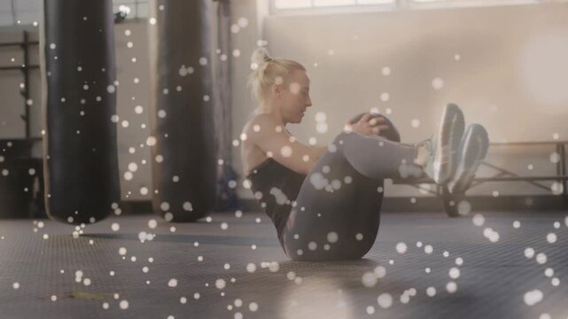 Vertical video: Starting set, woman in black tank rotating medicine ball at gym, working core