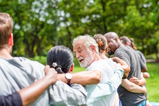 Diverse group embracing outdoors.