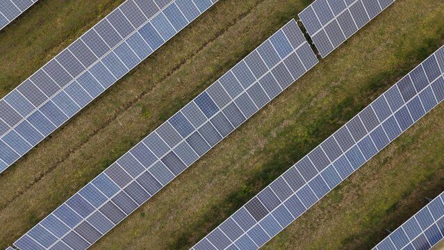 Aerial view of neatly arranged solar panels basking in the sun's glow near the former RAF Alconbury, Huntingdon, Cambridgeshire, United Kingdom.