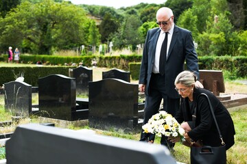 Somber cemetery visit scene.